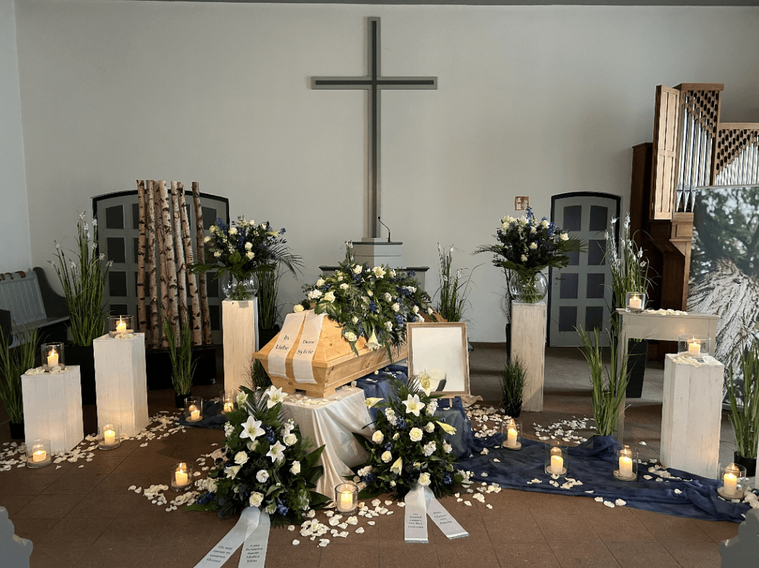 Aufbahrung mit Sarg und Blumenschmuck in einer Kirche | Bestattungsinstitut Wulf in Ahrensburg